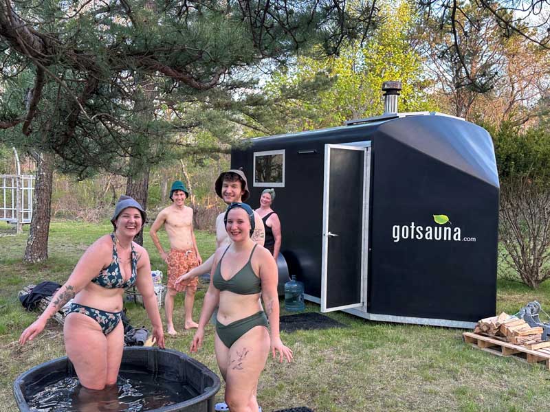 People enjoying small pool and portable sauna.